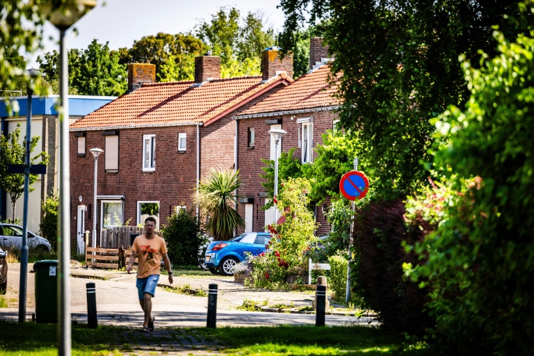 Un habitant marche dans une rue d’un quartier résidentiel du village de Moerdijk, dans le sud des Pays-Bas, le 22 juin 2026. Moerdijk est un village portuaire de 1.150 habitants placé entre les ports de Rotterdam et d'Anvers, en Belgique. C'est ici que le gouvernement néerlandais a choisi d'implanter une zone destinée à recevoir l'électricité produite par les parcs éoliens en mer et à rendre plus durable l'industrie portuaire du pays