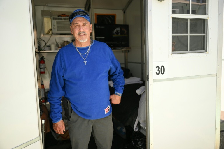 Michael Reyes pose devant la micro-maison en plastique où il est hébergé par l'association Hope the Mission, à Los Angeles, le 1er juin 2026
