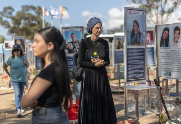 Des Israéliennes se recueillent au mémorial dressé pour les victimes de l'attaque du 7-Octobre contre le festival Nova, le 6 octobre 2026 à Reim en Israël