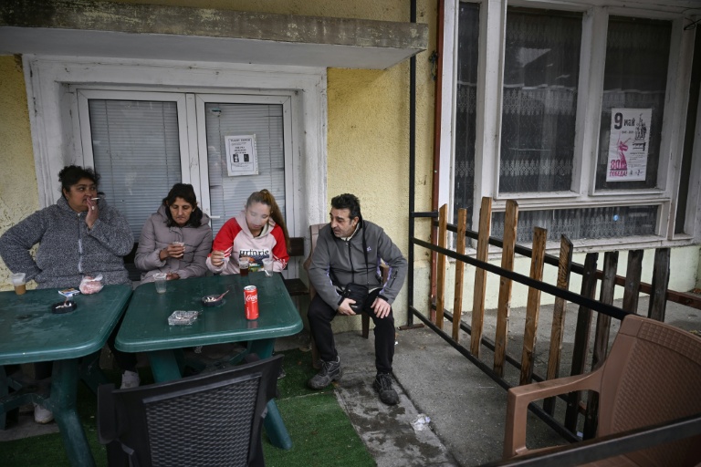 Des habitants prennent un café devant une épicerie du village de Chuprene, le 7 décembre 2025 en Bulgarie