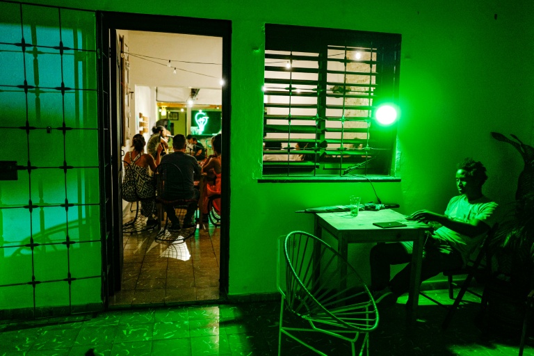 Un jeune homme regarde son téléphone au bar La Bombilla verde, à La Havane, le 27 septembre 2026