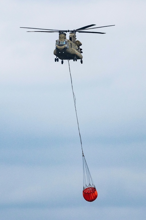 Un hélicoptère Chinook transporte une cargaison d'eau lors des opérations contre les incendies de forêt dans la réserve naturelle des Hautes Fagnes, près de Spa, le 19 août 2026 en Belgique