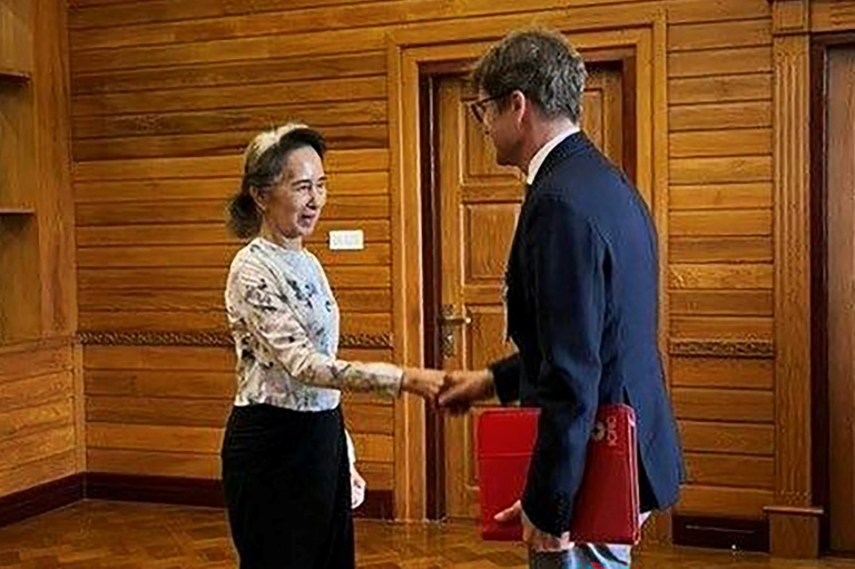 Cette photo, prise et diffusée le 3 août 2026 par le Bureau présidentiel de la presse et de l'information (PPIB) de Birmanie, montre l'ancienne dirigeante Aung San Suu Kyi (à gauche), détenue en résidence surveillée, lors d'un entretien avec Arnaud de Baecque, représentant résident du Comité international de la Croix-Rouge (CICR) en Birmanie, à Naypyidaw.