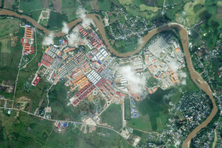 Photo satellite de Planet Labs PB, prise et diffusée le 9 novembre 2025, montrant le complexe KK Park après une opération militaire ayant causé des dégâts dans ce centre d'arnaques en ligne, dans le canton de Myawaddy, à l'est de la Birmanie, en face au district de Mae Sot (en haut et à droite), dans la province thaïlandaise frontalière de Tak