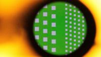 A silicon wafer seen magnified through the lens of a microscope