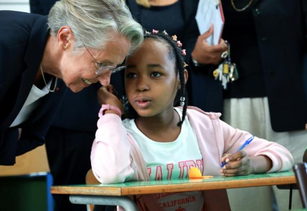 La ministre de l'Education Elisabeth Borne, discute avec une élève à l'occasion de la rentrée scolaire dans le quartier de Primat, à Saint-Denis de la Réunion, sur l'île de La Réunion, le 19 août 2025