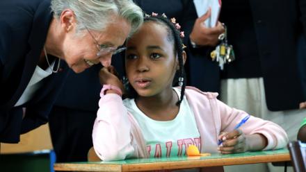 La ministre de l'Education Elisabeth Borne, discute avec une élève à l'occasion de la rentrée scolaire dans le quartier de Primat, à Saint-Denis de la Réunion, sur l'île de La Réunion, le 19 août 2025