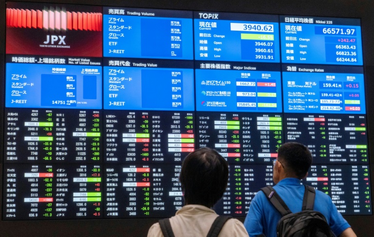 Des visiteurs devant les cours des valeurs à la Bourse de Tokyo le 1er juin 2026