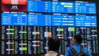 Des visiteurs devant les cours des valeurs à la Bourse de Tokyo le 1er juin 2026