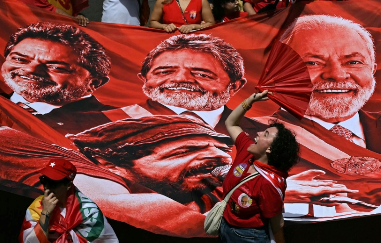 Des partisans du président brésilien de gauche, Luiz Inacio Lula da Silva, devant une bannière géante à son effigie lors d'un meeting de campagne à Rio, le 2 octobre 2026 