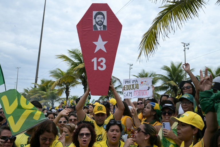 Un partisan du candidat à la présidence du Brésil Flavio Bolsonaro tient un cercueil en carton portant une photo du président Luiz Inacio Lula da Silva lors d'un rassemblement dans le quartier de Barra da Tijuca, à Rio de Janeiro, au Brésil, le 24 octobre 2026