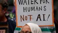 Une personne brandit une pancarte indiquant "De l'eau pour les humains, pas pour l'IA" lors d'une manifestation contre l'approbation d'un centre de données prévu dans les plans de réaménagement du quartier de Brick Lane, le 4 septembre 2026 à Londres