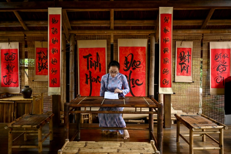 Une femme lit un document à la maison de calligraphie du Temple de la Littérature, dédié à l'ancien philosophe chinois Confucius, le 19 mai 2025 à Hanoï, au Vietnam