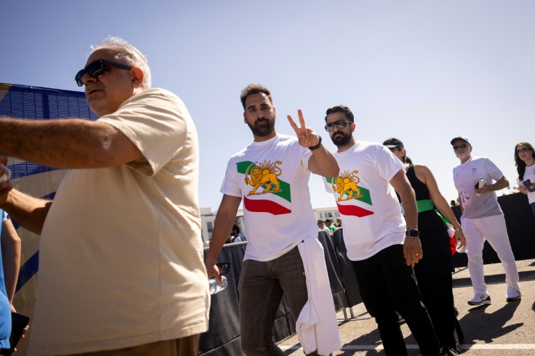 Des supporters iraniens font la queue pour rentrer dans le SoFi Stadium, près de Los Angeles, avec le drapeau utilisé par l'Iran avant la révolution islamique, le 15 juin 2026