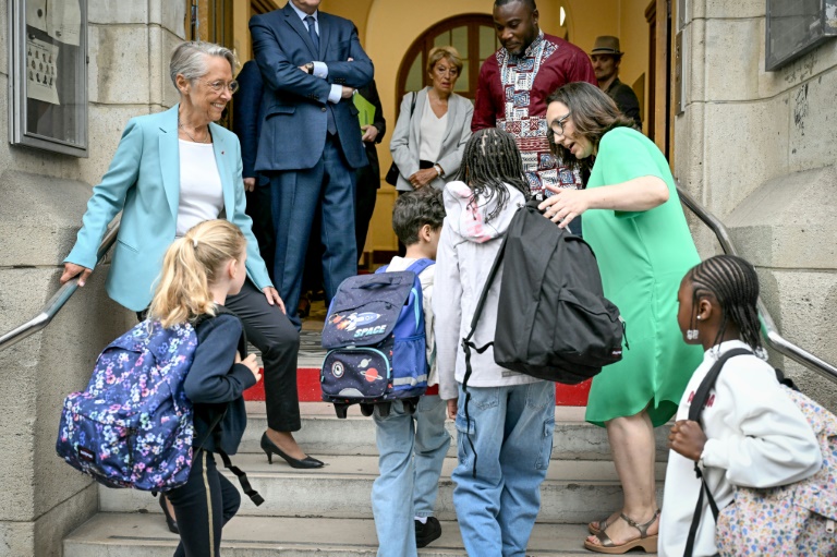 La ministre française de l'Éducation Elisabeth Borne (à gauche) accueille les élèves arrivant à l'école élémentaire publique Vigée-Lebrun le premier jour de classe après les vacances d'été, à Paris, le 1er septembre 2025