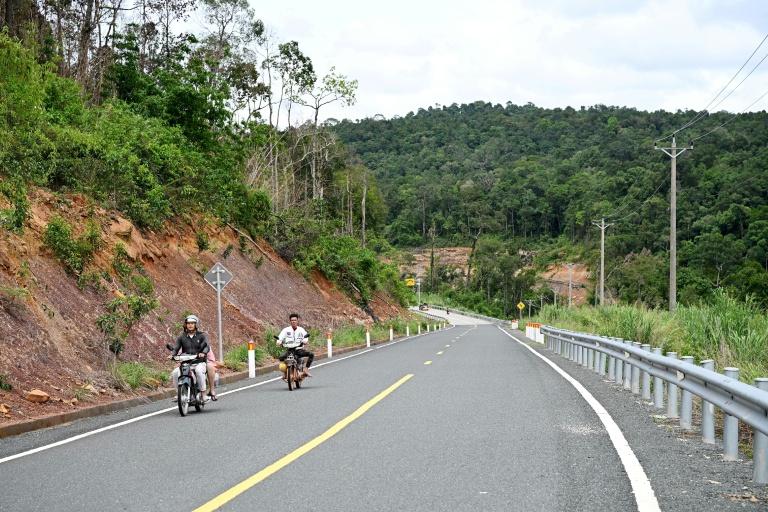 Des motocyclistes sur une route du parc national des Cardamomes, dans la province de Koh Kong, le 11 juin 2026 au Cambodge