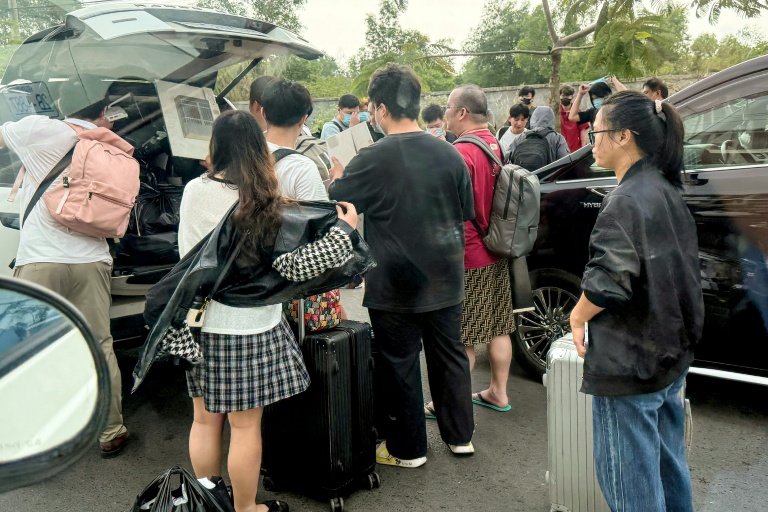 Des personnes chargent leurs bagages dans des véhicules après avoir quitté un complexe soupçonné d'être un centre d'escroquerie à Sihanoukville, le 15 janvier 2026 au Cambodge