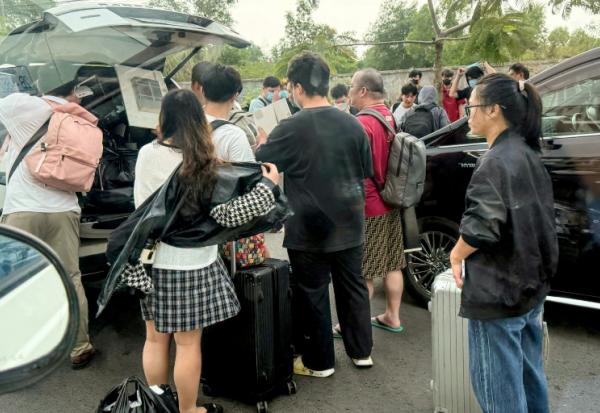 Des personnes chargent leurs bagages dans des véhicules après avoir quitté un complexe soupçonné d'être un centre d'escroquerie à Sihanoukville, le 15 janvier 2026 au Cambodge