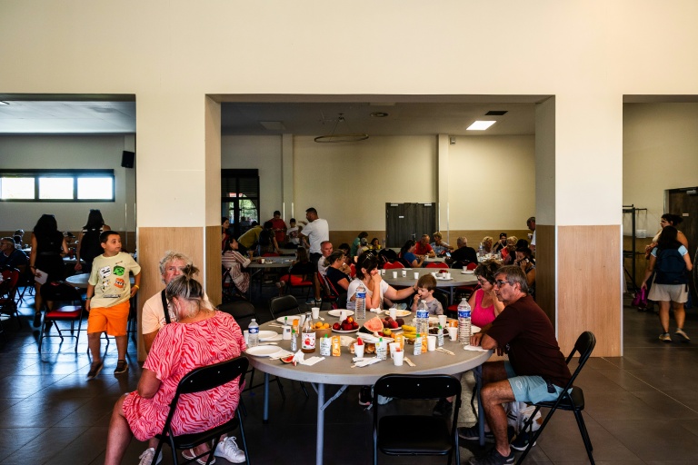 Des touristes et des personnes évacués prennent un petit déjeuner dans une salle à Canet-en-Roussillon (sud) le 3 juillet 2026.