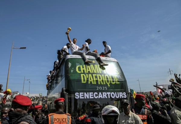 Les Sénagalais champions d'Afrique présentent leur trophée à la foule de Dakar, mardi 20 janvier 2026.