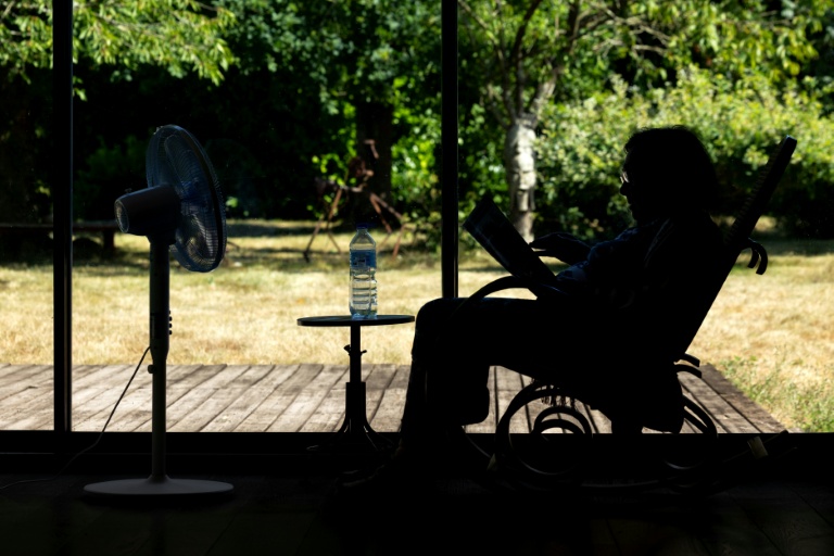 Une personne âgée assise face à un ventilateur à Pont-Audemer, dans l'Euroe, le 12 juillet 2026 lors d'une vague de chaleur en France