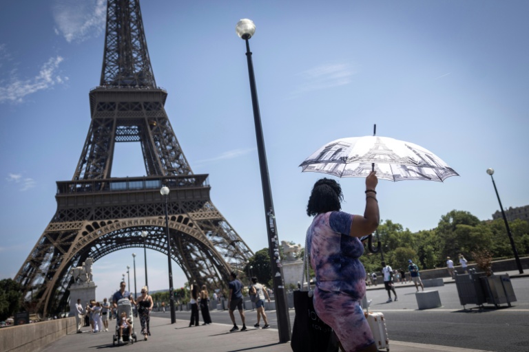 Une touriste se protège du soleil sous un parapluie, le 10 juillet 2026 à Paris 