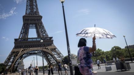 Une touriste se protège du soleil sous un parapluie, le 10 juillet 2026 à Paris 