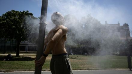 Un homme se rafraîchit sous une fontaine à Paris le 24 juin 2026 