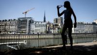 Une jeune femme s'hydrate pendant la canicule, le 24 juin 2026 à Paris