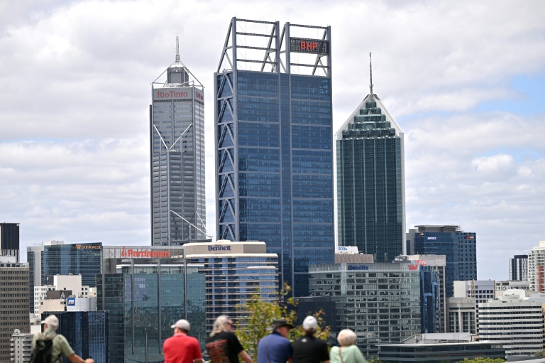 Les logos du géant minier australien BHP (centre) et de la multinationale minière et métallurgique Rio Tinto (gauche), sont visibles sur les immeubles de leurs bureaux à Perth, en Australie, le 24 novembre 2025