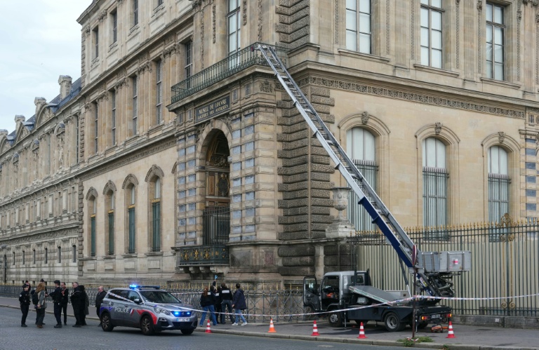 Des policiers près d'un monte-meubles utilisé par des cambiroleurs pour pénétrer dans le musée du Louvre, le 19 octobre 2025 à Paris