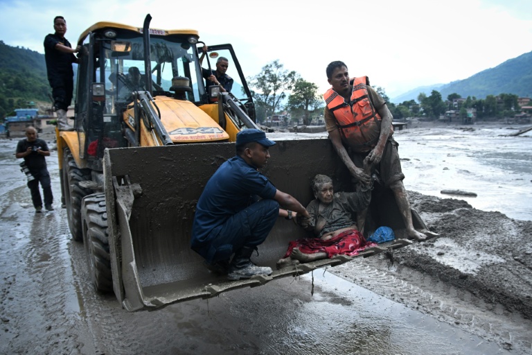 Les secouristes évacuent une personne ayant survécu à la crue soudaine à Devghat, dans le district de Nuwakot au Népal, le 26 août 2026