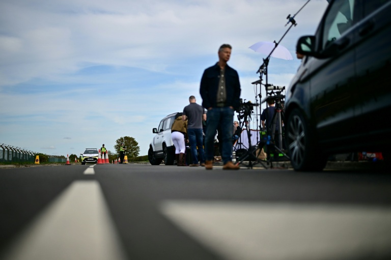 Des journalistes près d'un cordon de police devant la base aérienne de Fairford, le 28 septembre 2026 dans le sud-ouest de l'Angleterre, au lendemain d'une opération de police antiterroriste britannique