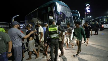 Des membres des forces de l'ordre marocaines acheminent par bus vers leurs villes d'origine des personnes qui avaient pénétré illégalement dans l'enclave espagnole de Ceuta, sur la côte nord du Maroc, le 1er août 2026 à Fnideq 