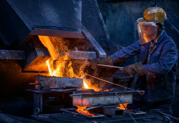 Un ouvrier verse une barre d'alliage de cuivre dans un four de fusion à l'usine de tubes MPG (Mendener Präzisionsrohr GmbH) à Menden, dans l'ouest de l'Allemagne, le 18 juin 2026