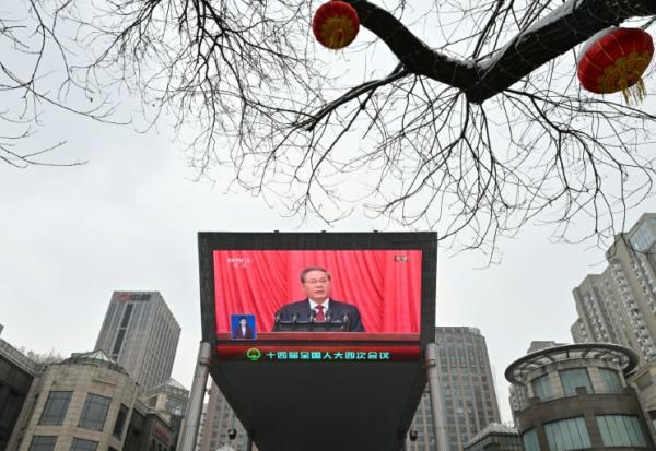Un écran montre le Premier ministre chinois Li Qiang lors de l'ouverture du grand événement annuel des Deux sessions à Pékin, en Chine, le 5 mars 2026