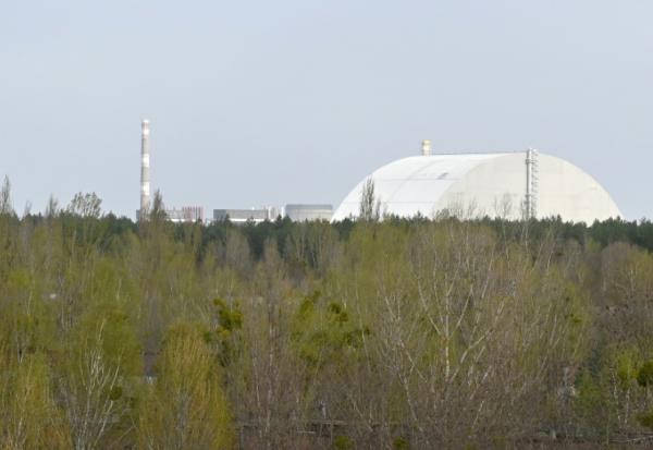L'enceinte de confinement recouvrant le réacteur accidenté de la centrale nucléaire de Tchernobyl, vu depuis la ville fantôme de Pripyat, le 23 avril 2026, près de 40 ans après la catastrophe