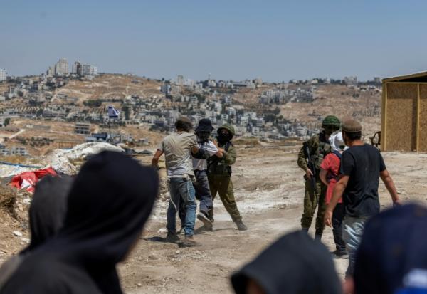 Des membres des forces israéliennes interviennent au milieu d'une dispute entre des colons et des militants israéliens dans un avant-poste, dans le village palestinien de Jannatah, en Cisjordanie occupée, le 25 août 2026