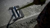 La saunière française Annabelle Poinot récolte la fleur de sel qui forme une fine croûte à la surface de l’eau de mer acheminée à travers les bassins d’un marais salant à Château-d’Oléron, sur l’île d’Oléron, dans le sud-ouest de la France, le 17 juin 2026