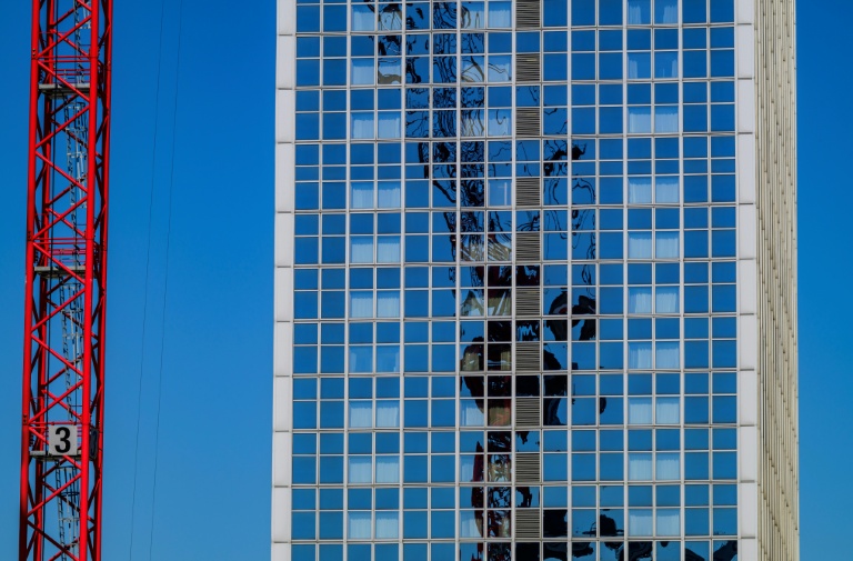 Une grue se reflète sur la façaade d'un immeuble à Berlin le 1er mai 2024