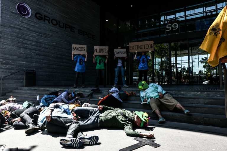 Des manifestants se rassemblent devant le siège du groupe bancaire BPCE avant l'assemblée générale de TotalEnergies, à Paris, le 16 mai 2025