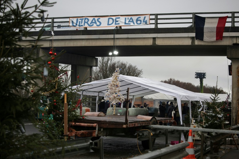 Des sapins de Noël installés sur un barrage de l'A64 par les agriculteurs en colère, le 22 décembre 2025 à Carbonne, en Haute-Garonne 