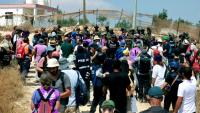 Des Palestiniens et des militants rassemblés pour manifester contre des colons israéliens qui assiègent la maison d'une famille palestinienne dans le village de Qusra, au sud de la ville de Naplouse, en Cisjordanie occupée, le 14 août 2026