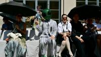 Un invité portant un masque d'extraterrestre assiste au défilé de la collection Thom Browne lors de la Fashion Week Homme Printemps/Été 2027 de Milan, à Milan, le 22 juin 2026