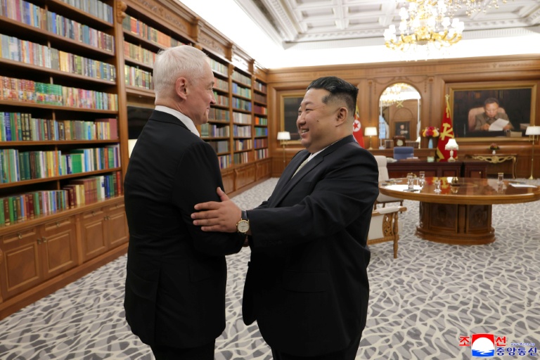 Photo prise le 26 avril 2026 et diffusée le 27 avril 2026 par l'agence de presse officielle nord-coréenne KCNA, montrant le dirigeant nord-coréen Kim Jong Un (d) et le ministre russe de la Défense Andreï Belooussov au siège du Comité central du Parti des travailleurs de Corée à Pyongyang