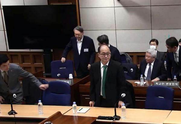 Cette capture d'écran tirée d'une vidéo distribuée par le tribunal central de Séoul et diffusée par l'agence Yonhap montre l'ancien président sud-coréen Yoon Suk Yeol (2e rangée, à gauche) assistant à un procès pour insurrection au tribunal central de Séoul, le 19 février 2026