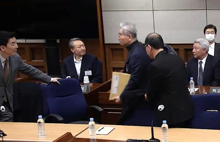 Cette capture d'écran tirée d'une vidéo distribuée par le tribunal central de Séoul et diffusée par l'agence Yonhap montre l'ex-président sud-coréen Yoon Suk Yeol (2e à gauche) assistant à son procès pour insurrection à Séoul, le 19 février 2026