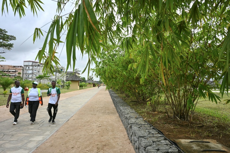 Des visiteurs marchent le 1er août 2025 dans le parc urbain d'Akouédo à Abidjan, construit sur le site d'une ancienne décharge