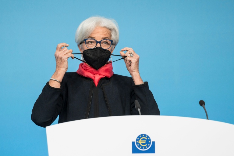 La présidente de la BCE Christine Lagarde retire son masque de protection pour s'exprimer lors d'une conférence de presse à Francfort, le 16 décembre 2021 pendant la période du Covid