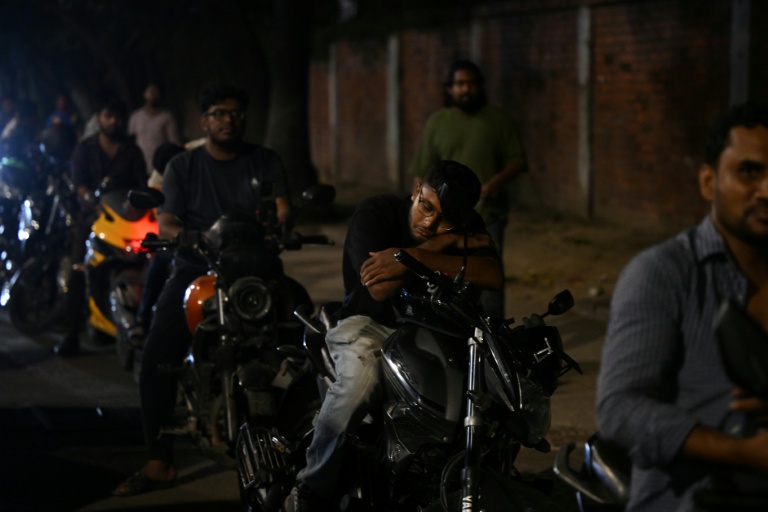 Un homme fait la sieste sur sa moto dans une file d'attente pour du carburant à Dacca, capitale du Bangladesh, le 21 avril 2026